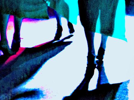 Drei Frauen, in festlicher Kleidung unterwegs, man sieht nur die Röcke und Beine von hinten.