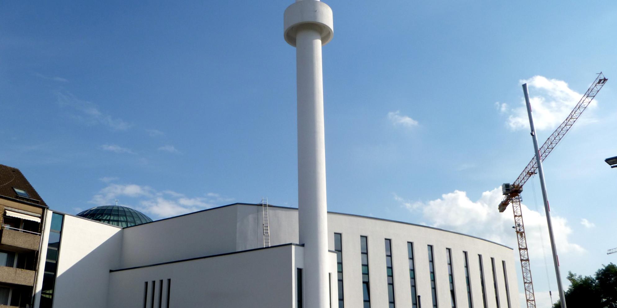Moscheegebäude mit einem Kran dahinter.
