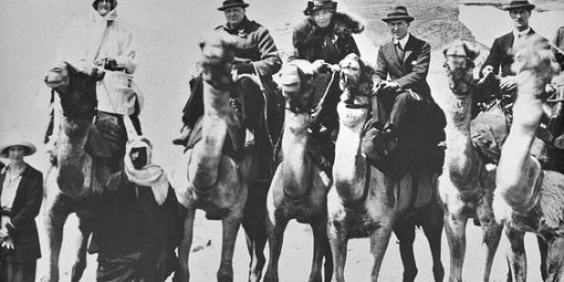 Ein Foto aus dem Jahr 1921. Personen reiten auf Kamelen, aufgenommen vor der Statue der Sphinx in Ägypten: das Ehepaar Churchill, Gertrude Bell und T. E. Lawrence.