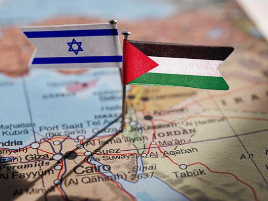 Links die Flagge von Israel, rechts von Palästina, auf einer Landkarte.