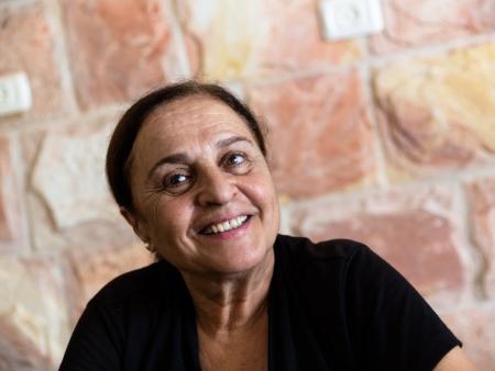 Porträt einer Frau, der palästinensischen Autorin Sumaya Farhat-Naser, vor einer Mauer