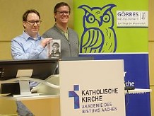 Zwei Männer an einem Rednerpult, einer davon ist der Buchautor Patrick Peters, der andere ein Studienleiter der Akademie.