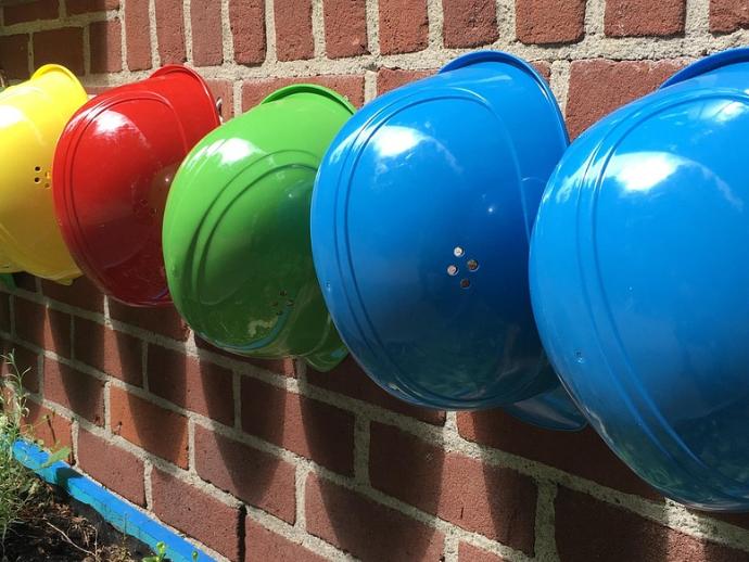 Eine Reihe von Helmen hängt an einer Wand.